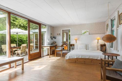 a bedroom with a bed and a patio with a table at 1601-Melby-Muldbjergvej-1 in Melby