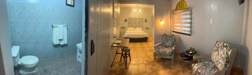 a bathroom with a bedroom with a bed and a toilet at Sunbloom Beachfront Hotel and Restaurant Zambales in Sinabacan