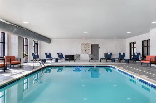 a pool in a hotel room with chairs and tables at Hampton Inn Detroit/Southgate in Southgate