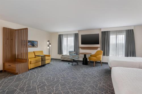 a hotel room with a bed and a living room at Hampton Inn Detroit/Southgate in Southgate