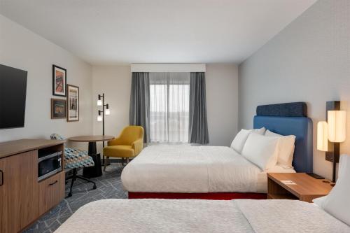 a hotel room with two beds and a television at Hampton Inn Detroit/Southgate in Southgate