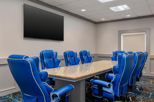 a conference room with a table and blue chairs at Hampton Inn Detroit/Southgate in Southgate
