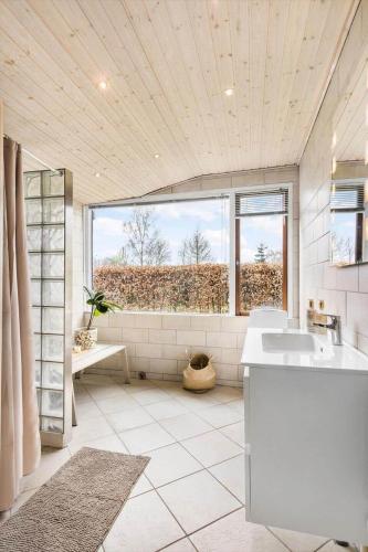 a bathroom with a sink and a large window at 1566-Dronningmolle-Vipstjertvej-12 in Dronningmølle