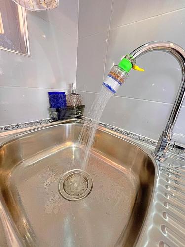 a bottle of water is coming out of a sink at Luxury Homely Apt studio with pool in Kisumu