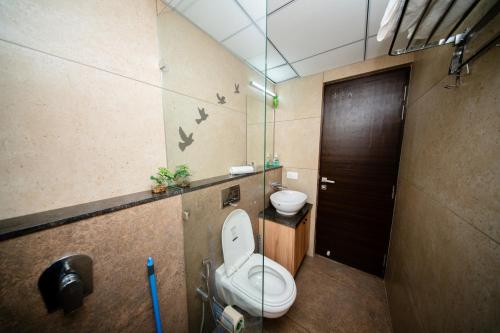 a bathroom with a toilet and a door with birds on the wall at Casa Luma 1BHK Furnished Siolim Swimming Pool Jacuzzi Sauna in Cunchelim