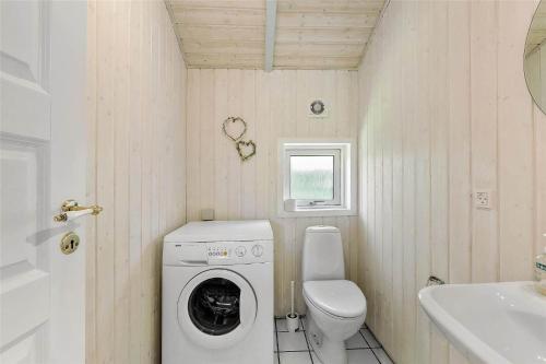 a small bathroom with a washing machine and a toilet at 617-N-Melby-Bakkely-8-B in Melby