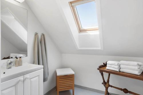 a white bathroom with a sink and a window at 1602-Vejby-Brondsholmvej-33 in Vejby