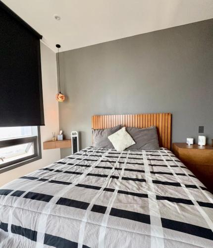 a bedroom with a bed with a black and white comforter at Stylish Loft for 4 Reforma CDMX Ideal Long Stay in Mexico City