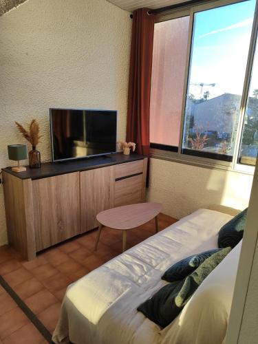 a bedroom with a bed and a flat screen tv at Appartement en résidence Valras-Plage in Valras-Plage