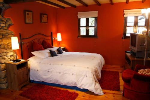 a bedroom with a large bed and a tv at El Trebano in Cardes