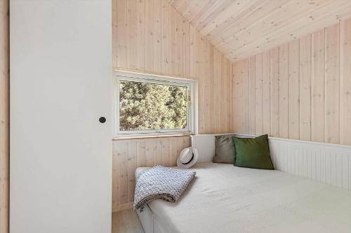 a small room with a bed and a window at 1643-Hundested-Vaeselvaenget-3 in Hundested