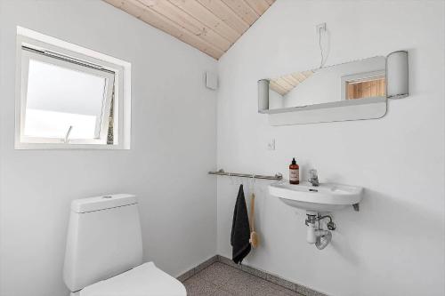 a white bathroom with a toilet and a sink at 1643-Hundested-Vaeselvaenget-3 in Hundested