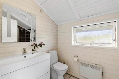 a bathroom with a toilet and a sink and a window at 1630-Frederiksvaerk-Munkebakken-2 in Frederiksværk