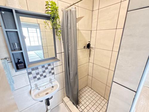 a bathroom with a shower and a sink at Sanctuary Guesthouse in Kimberley