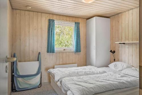 a bedroom with two beds and a window at 40703-Ulfborg-Helmklit-227 in Ulfborg
