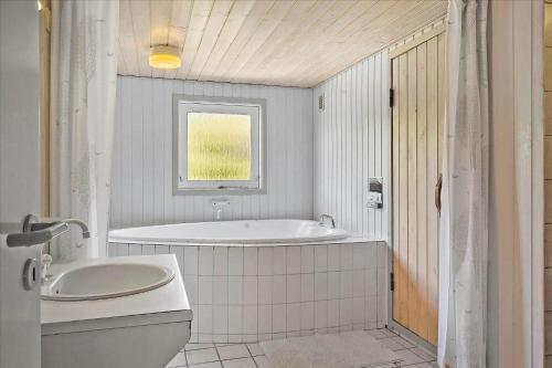 a white bathroom with a tub and a sink at 40703-Ulfborg-Helmklit-227 in Ulfborg