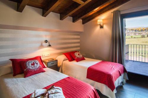 a bedroom with two beds with red pillows and a window at Casa de 7 suites y vistas 360. Les Feixes Llargues in Bolvir