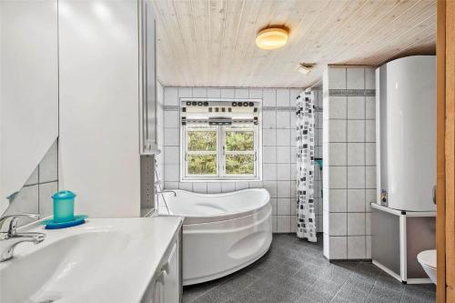 a white bathroom with a tub and a sink at 10820-Ulfborg-Baekbyvej-113 in Ulfborg