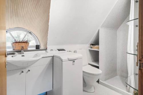 a white bathroom with a toilet and a sink at 10439-Ulfborg-Gaffelbjergvej-60 in Ulfborg