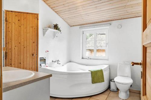 a bathroom with a tub and a toilet and a sink at 10831-Ulfborg-Graemvej-57 in Ulfborg