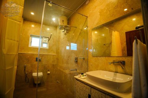 a bathroom with a sink and a toilet and a shower at Jai Ganesha Resort in Chālsa Mahābāri