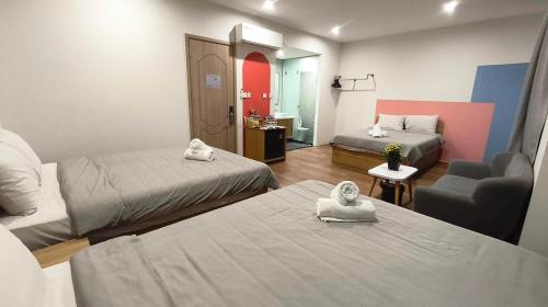 a hotel room with two beds and a chair at LokoOne Central Hub in Hòa Bình