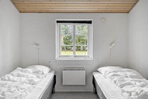 two beds in a room with a window at 30859-Ulfborg-Bellisvej-432 in Ulfborg