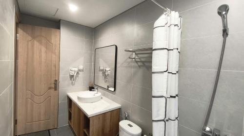 a bathroom with a sink and a toilet and a shower at LokoOne Central Hub in Hòa Bình