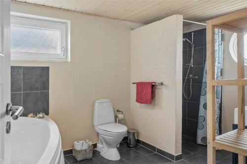 a bathroom with a toilet and a bath tub at 70029-Ulfborg-Vesterhavsgade-6 in Ulfborg