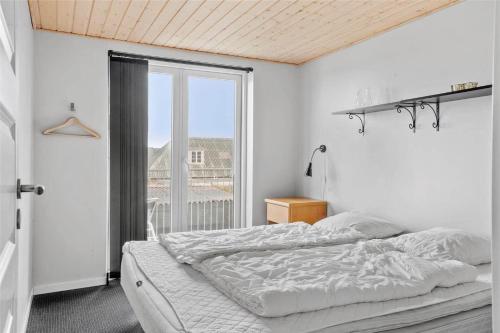 a bedroom with a bed and a large window at 70029-Ulfborg-Vesterhavsgade-6 in Ulfborg