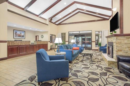 a living room with blue chairs and a fireplace at Ramada by Wyndham Denver International Airport in Denver