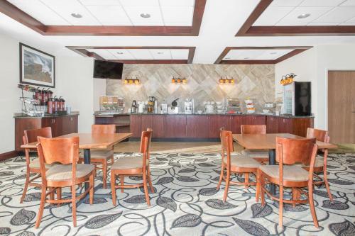 a dining room with wooden tables and chairs at Ramada by Wyndham Denver International Airport in Denver