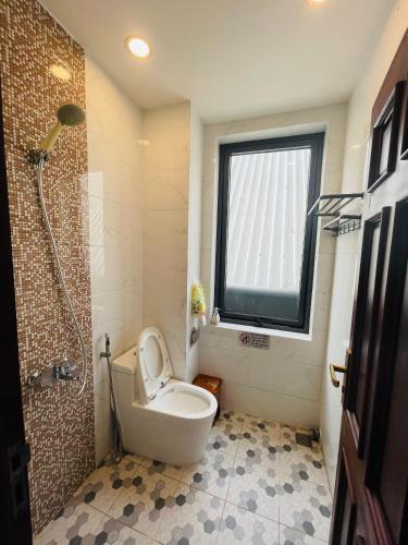 a bathroom with a toilet and a window and a shower at Tôm Tít Homestay in Phú Quốc