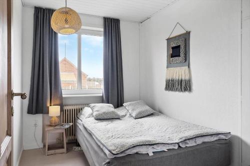 a small bedroom with a bed and a window at 70099-Ulfborg-Klitrosevej-2 in Ulfborg