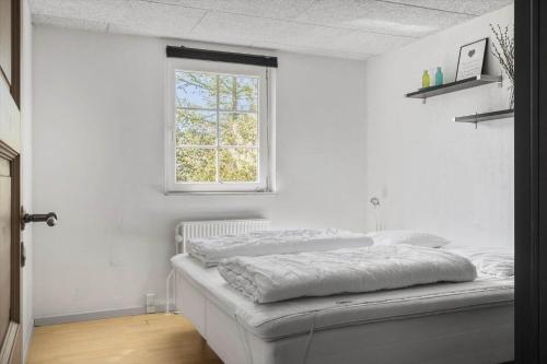 a white bedroom with a bed and a window at 30876-Ulfborg-Krogsgardvej-5 in Ulfborg