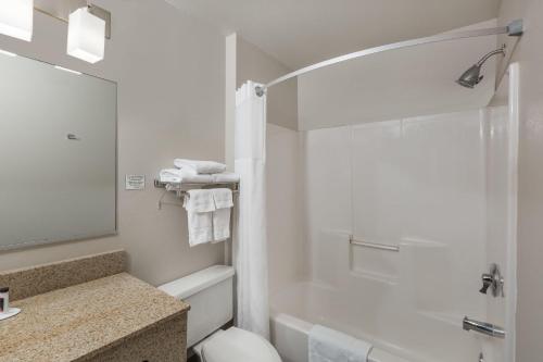 a bathroom with a shower and a toilet and a sink at Ramada by Wyndham Platte City KCI Airport in Platte City
