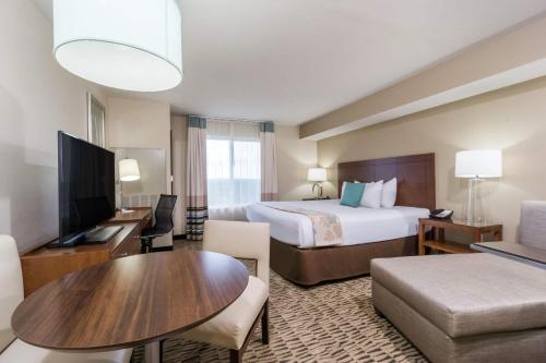 a hotel room with a bed and a living room at Hawthorn Suites by Wyndham Wheeling at The Highlands in Triadelphia