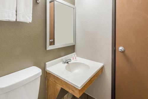a bathroom with a white sink and a mirror at Super 8 by Wyndham Bedford in Bedford