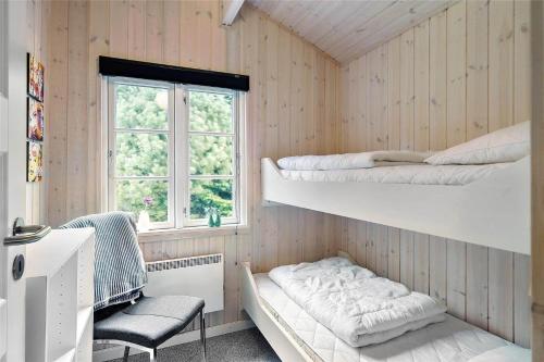 a room with two bunk beds and a chair at 30121-Ulfborg-Klovervej-474 in Ulfborg
