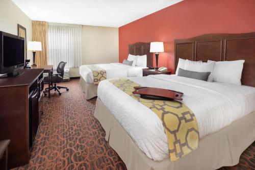 a hotel room with two beds and a desk at Baymont by Wyndham Oklahoma City/Quail Springs in Oklahoma City