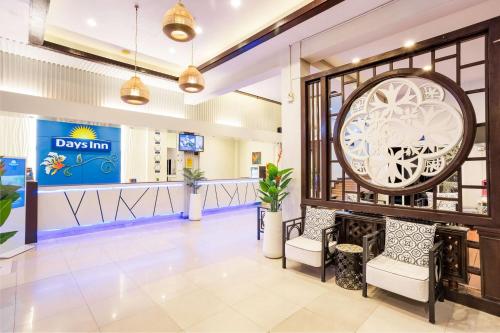 a lobby of a day inn with a clock on the wall at Days Inn by Wyndham Patong Beach in Patong Beach
