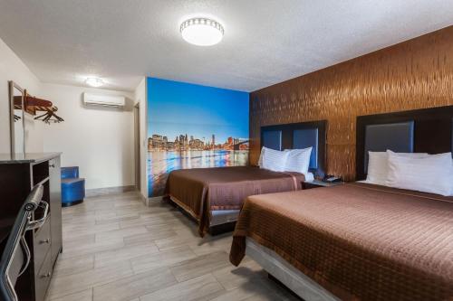 a hotel room with two beds and a television at Travelodge by Wyndham South Hackensack in South Hackensack