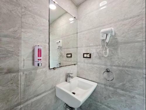 a bathroom with a sink and a mirror at The Platinum in Kolkata