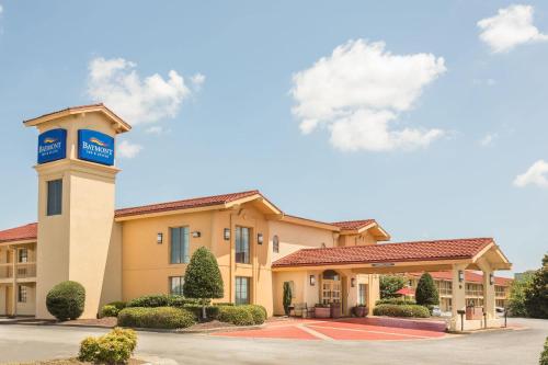 a hotel with a clock tower in a parking lot at Baymont by Wyndham Greenville Woodruff Rd in Greenville