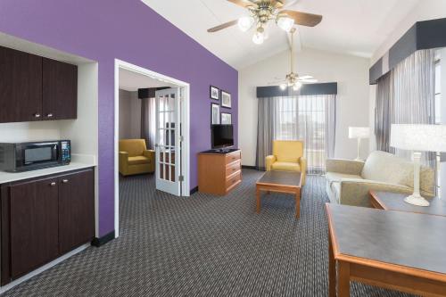 a living room with a couch and a table at Baymont by Wyndham Greenville Woodruff Rd in Greenville