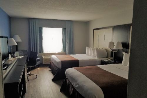 a hotel room with two beds and a window at Wyndham Garden Hotel - Jacksonville in Jacksonville