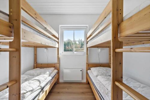 a room with three bunk beds and a window at 51401-Ulfborg-Sdr-Fjandvej-46 in Ulfborg