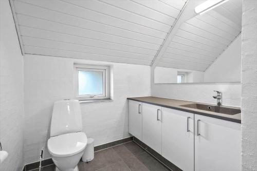 a white bathroom with a toilet and a sink at 51401-Ulfborg-Sdr-Fjandvej-46 in Ulfborg