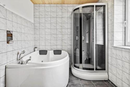 a bathroom with a white tub and a shower at 70751-Ulfborg-Fjordvaenget-13 in Ulfborg