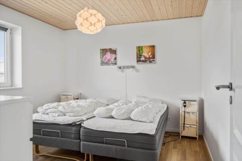 a bedroom with a bed with white sheets on it at 70751-Ulfborg-Fjordvaenget-13 in Ulfborg
